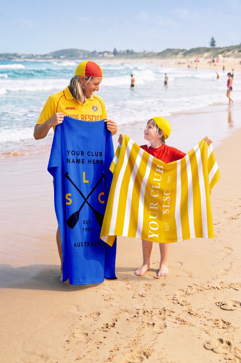 Child holding a personalised towel at the beach